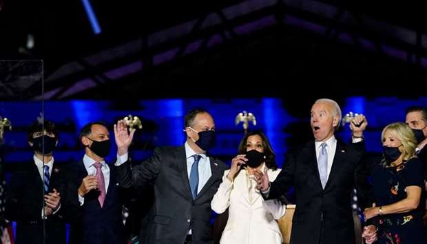 Vice President-elect Kamala Harris (3rd R), husband Doug Emhoff, President-elect Joe Biden and his wife Jill Biden react after confetti was released after delivering remarks in Wilmington, Delaware, after being declared the winners of the presidential election.