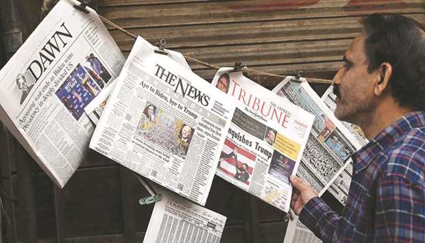 A man at a newspaper stand in Lahore looks at headlines for reports on Joe Bidenu2019s victory in the US presidential elections.