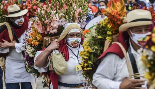 Men an women carry flower arrangements known as ,Silletas, at the ,Silleteros, parade during Medellinu00abs Flower Festival, amid the Covid 19 pandemic in Santa Elena municipality near Medellin