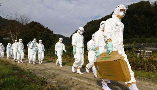 Officials in protective suits head to a poultry farm for a suspected bird flu case in Higashikagawa, western Japan.