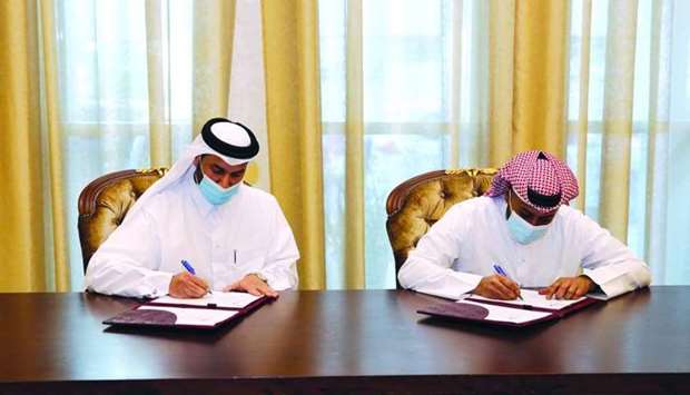 Sheikh Mohamed bin Khalid al-Thani and Khalifa Hassan al-Jehani signing the agreement.