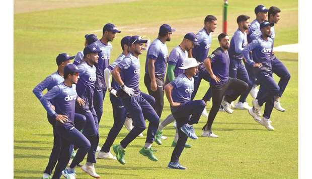 Bangladeshu2019s players stretch during a training session in Dhaka yesterday. (Right) Pakistanu2019s Mohamed Rizwan plays a shot during a training session yesterday. (AFP)