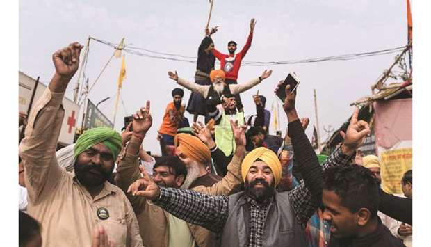 Farmers celebrate after Prime Minister Modi announced the repeal of three agricultural reform laws that sparked almost a year of huge protests by farmers across the country in Singhu, New Delhi, on Friday.