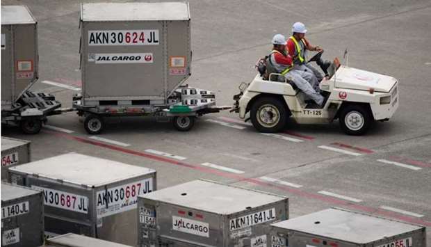 A member of Japan Airlines Co ground staff drives a cart transporting cargo containers at Haneda Airport in Tokyo. Ground handling providers are facing severe skills shortages and challenges in retaining and recruiting staff as the global airline industry slowly recovers from the Covid-19 pandemic, which virtually halted activity at airports around the world in the second quarter of 2020.