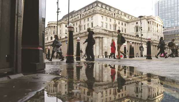 Pedestrians pass the Bank of England in the City of London. The BoE will enforce its green criteria in corporate bond purchases for the first time, establishing a blueprint for investing in a part of the credit world rife with greenwashing.