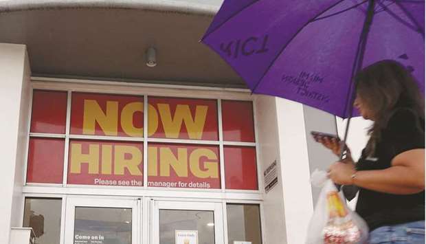 A u2018Now Hiringu2019 sign hanging above the entrance to a McDonaldu2019s restaurant in Miami Beach, Florida. In a milestone in the US economyu2019s recovery from the pandemic, the US government said yesterday that new claims for unemployment benefits have fallen below their level before Covid-19 struck and caused mass layoffs.