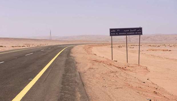 A road sign sits beside a desert highway indicating the distance to the bay at Ras Hameed, Saudi Arabia (file). Itu2019s here that Saudi Arabia plans Neom, a city from scratch that will be bigger than Dubai and have more robots than humans.