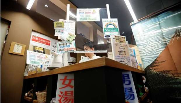 A plastic sheet and advisory to prevent the spread of coronavirus disease are pictured at the reception counter of Japanese public bathhouse, or sento, 'Dai-ni Takara-yu' yesterday in Tokyo, Japan