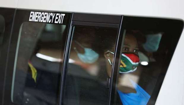 A passenger in a taxi wears a face mask with colours of the South African flag after the announcement of a British ban on flights from South Africa because of the detection of a new coronavirus disease variant, in Soweto, South Africa. REUTERS