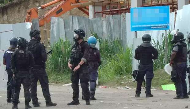 Australian Federal Police officers patrolling with local police in Honiara after two days of rioting which saw thousands ignore a government lockdown order, torching several buildings around the Chinatown district including commercial properties and a bank branch. (AFP)