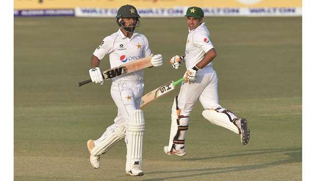 Pakistanu2019s Abid Ali (right) and teammate Abdullah Shafique run between the wickets on the second day of the first Test against Bangladesh in Chittagong yesterday. (AFP)