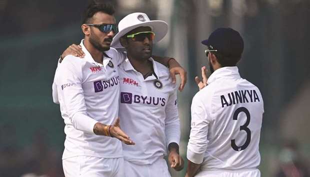 Indiau2019s Axar Patel (left) celebrates with teammate Suryakumar Yadav (centre) and captain Ajinkya Rahane after taking the wicket of New Zealandu2019s Henry Nicholls (not pictured) on the third day of the first Test at the Green Park Stadium in Kanpur yesterday. (AFP)