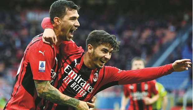 AC Milanu2019s Alessio Romagnoli (left) celebrates with a teammate after scoring his teamu2019s first goal during the Serie A match against Sassuolo at the San Siro Stadium in Milan yesterday. (AFP)