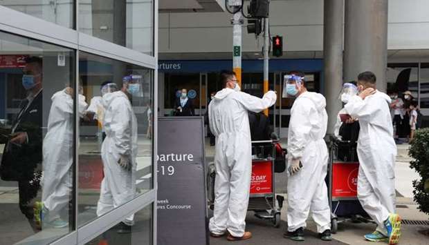 Travellers wear personal protective equipment outside the international terminal at Sydney Airport, as countries react to the new coronavirus Omicron variant amid the coronavirus disease pandemic, in Sydney, Australia. REUTERS