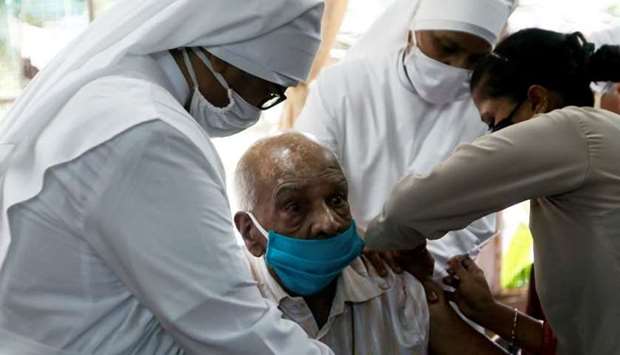 Nuns hold an elderly man as he receives a dose of Covaxin coronavirus disease vaccine manufactured by Bharat Biotech, at a home for elderly in Mumbai, India, August, 2. REUTERS