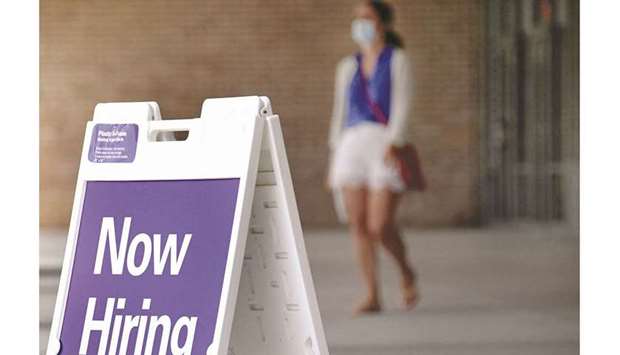 A woman walks by a u201cNow Hiringu201d sign outside a store in Arlington, Virginia (file). Initial claims for state unemployment benefits fell 14,000 to a seasonally adjusted 269,000 for the week ended October 30, the Labor Department said on Thursday.