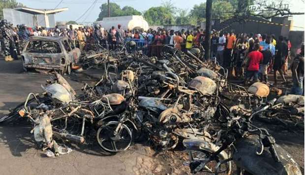 People watch burnt car and motorcycles after a fuel tanker explosion in Freetown, Sierra Leone. National Disaster Management Agency-Sierra Leone/Handout via REUTERS