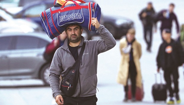 A man carries a bag on his head as he travels from Russia across the border to Georgia at the Zemo Larsi/Verkhny Lars station, Georgia. (Reuters)