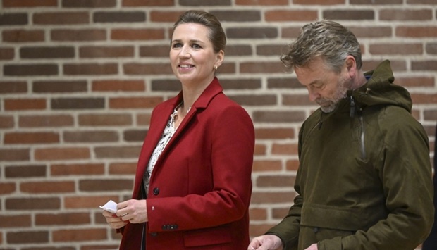Denmark's Prime Minister and head of the Social Democratic Party Mette Frederiksen and her husband Bo Tengberg arrive at a polling center. (AFP)