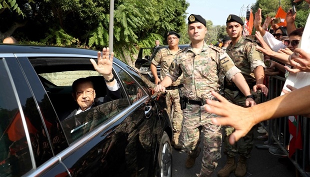 Outgoing Lebanese President Michel Aoun greets supporters from a car as he leaves the presidential palace (Reuters)