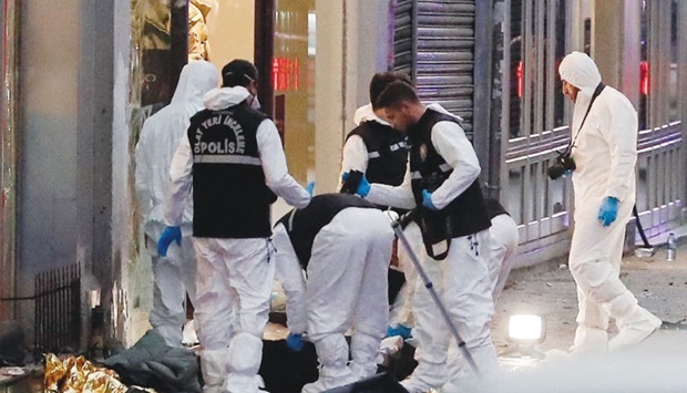 Police members work near the bodies of unidentified people after an explosion on busy pedestrian Istiklal street in Istanbul yesterday.