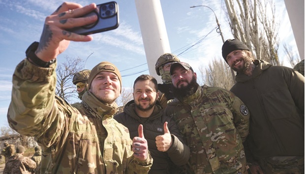 Ukrainian President Volodymyr Zelensky (second left) posing for a selfie with Ukrainian servicemen during his visit to the newly liberated city of Kherson. (AFP)