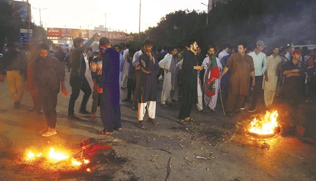 Supporters of former prime minister Imran Khan block a road following the shooting incident during a protest in Karachi, Pakistan, yesterday.