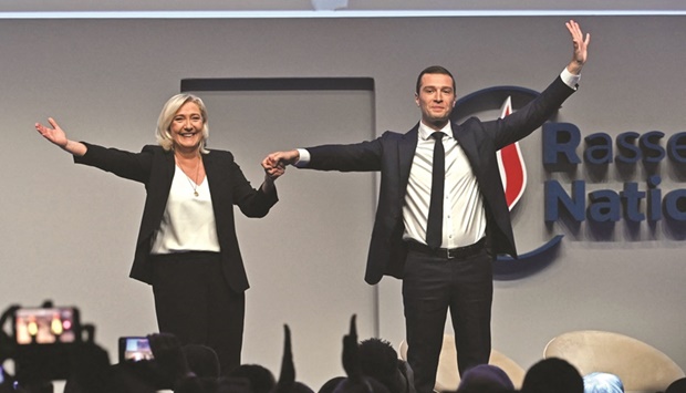 French far-right party Rassemblement National parliamentary group leader Marine Le Pen (left) and newly elected party president Jordan Bardella hold hands during the Rassemblement Nationalu2019s 18th congress in Paris yesterday. (AFP)