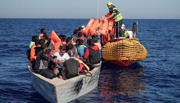 Crew members of NGO rescue ship give lifejackets to migrants on an overcrowded boat. (Reuters)
