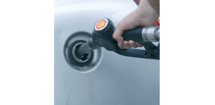 A driver fills up with fuel at a Shell petrol station in London. Oil prices recovered on Wednesday from sharp early losses to finish higher on news th
