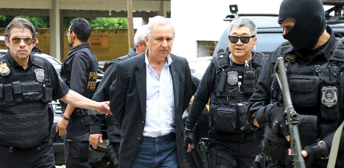 Businessman and rancher Jose Carlos Bumlai is escorted by federal police officers as he leaves the Institute of Forensic Science in Curitiba, Brazil, 