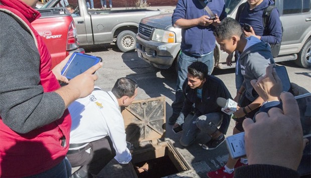 Journalists take pictures and record videos of a manhole of the sewer system through which drug kingpin Joaquin ,El Chapo, Guzman tried to escape during the military operation that resulted in his recapture in the city of Los Mochis, Sinaloa State, Mexico.