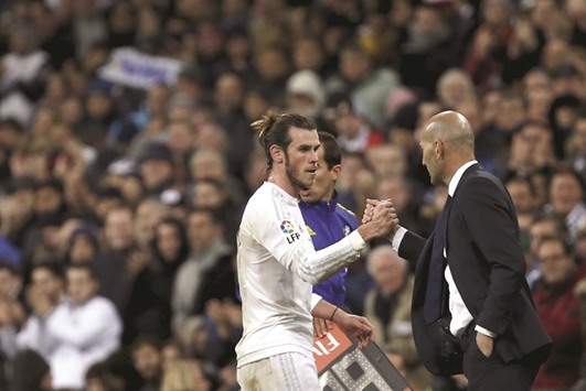 Real Madridu2019s new coach Zinedine Zidane greets his striker Gareth Bale as he leaves the pitch after the match against Deportivo.