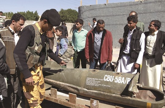 Yemenis gather around the remains of a rocket during a protest in front of the UN office in Sanaa yesterday, calling for an end to the military operations carried out by the coalition.