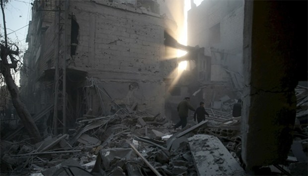 Residents inspect damage in a site hit by what activists said were airstrikes carried out by the Rus