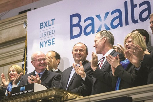 Ludwig Hantson, chief executive officer of Baxalta (centre), celebrates the companyu2019s IPO after ringing the opening bell above the floor of the New York Stock Exchange (file). Shares in the US biotech firm rose yesterday after it accepted Dublin-based pharmaceutical group Shireu2019s $32bn cash-and-stock bid aimed at forming a global biotech giant targeting rare diseases.