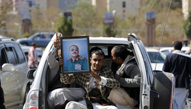 A man holds a picture of Yemen's former President Ali Abdullah Saleh as he rides a car in Sanaa on FRiday.