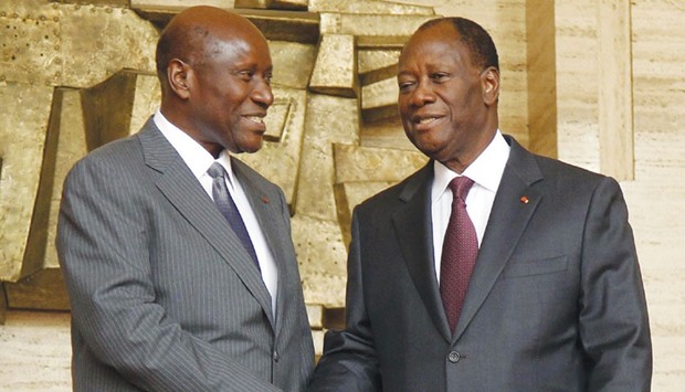 Ivory Coast President Alassane Ouattara (right) shakes hands with Prime Minister Daniel Kablan Duncan after the announcement of the new government at the presidential palace in Abidjan yesterday.