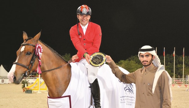 Turkeyu2019s Omer Karaevli, winner of the Special Two Phases, Art. 274.5.6 u2013 145cm event, receives his prize from Jassim Mohammad al-Emadi, representing AlHazm of Al Emadi enterprises at the Al Rayyan International Show Jumping Championship at the Qatar Equestrian Federation yesterday. PICTURES: Garsi lotfi