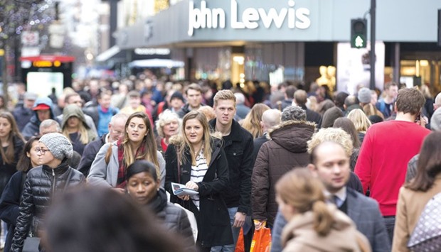 Pedestrians walk past a John Lewis store on Oxford Street in London. Having boosted growth for nine straight quarters, consumer spending in Britain could be up against restraints next year that will curb its momentum.