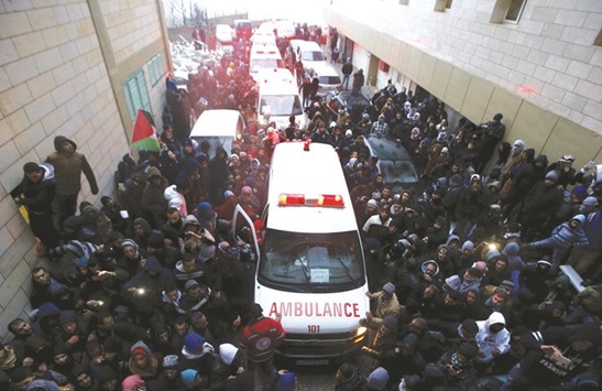 Ambulances transporting the bodies of Palestinians, arrive at a hospital in the West Bank city of Hebron.