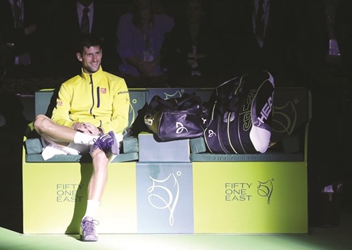 Novak Djokovic of Serbia smiles as he waits to receive his trophy after beating Rafael Nadal of Spain in the final of the Qatar Open.