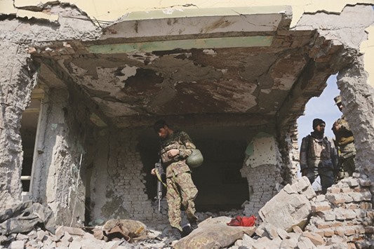 Afghan security personnel inspect a building used by insurgents to launch an attack on the Pakistan consulate in Jalalabad yesterday.