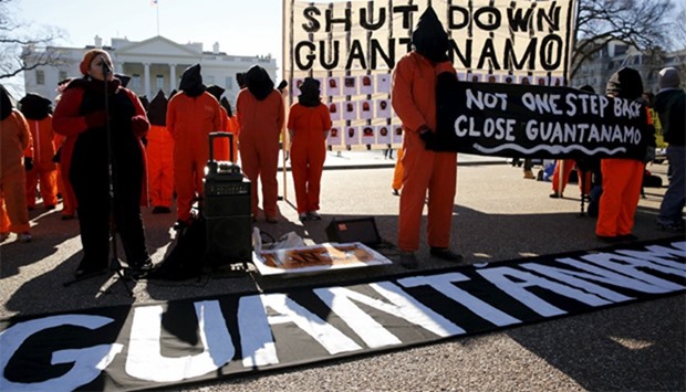Protesters in orange jumpsuits from Amnesty International USA and other organizations rally outside the White House to demand the closure of the US prison at Guantanamo Bay