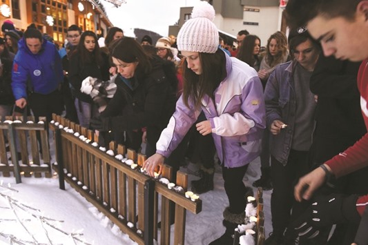 People place candles yesterday, at Les Deux Alpes resort in the French Alps, in tribute to the victims of the avalanche.