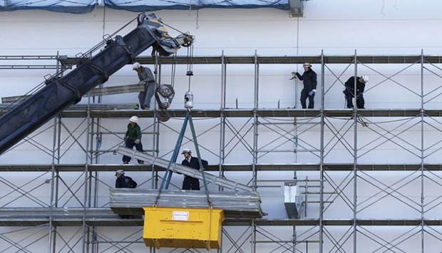 Men work near a crane at a construction site in Tokyo. Japanu2019s core machinery orders tumbled the most in 18 months in November after solid gains in prior months,  adding to uncertainty over the outlook as domestic demand stays subdued and Chinau2019s slowdown dims global growth prospects.