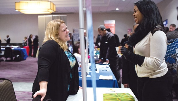 A recruiter (left) speaks with a job seeker during a job fair in Detroit. Initial claims for state unemployment benefits increased 7,000 to a seasonally adjusted 284,000 for the week ended January 9, the Labour Department said yesterday.
