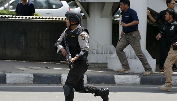 Policemen runs near the site of a blast in Jakarta, Indonesia. Reuters