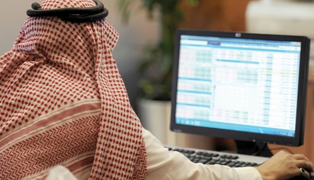 A Saudi investor monitors stock prices at the Al-Bilad Saudi Bank in Riyadh (file). The Saudi index tumbled 3.3% to close at 5,838 points yesterday, its lowest finish since March 2011, after a heavy wave of sales in the final hour of trade.