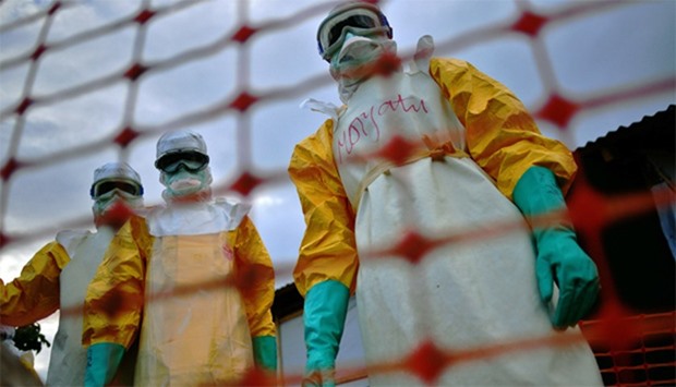 Medical staff wearing protective clothing treat the body of an Ebola victim